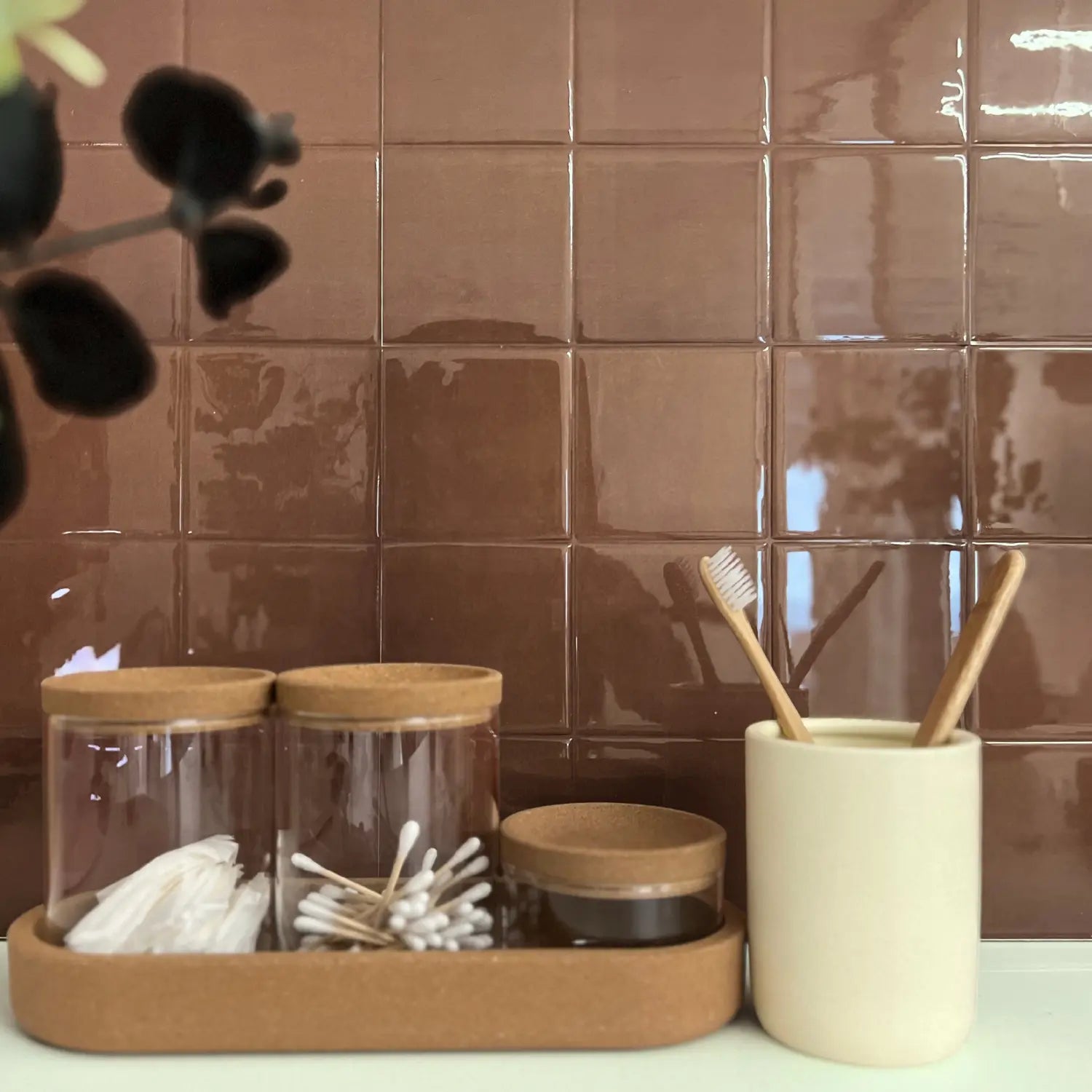 Stickwoll Bathroom setting with jars, toothbrushes, and a tray against a brown peel and stick tiled wall.