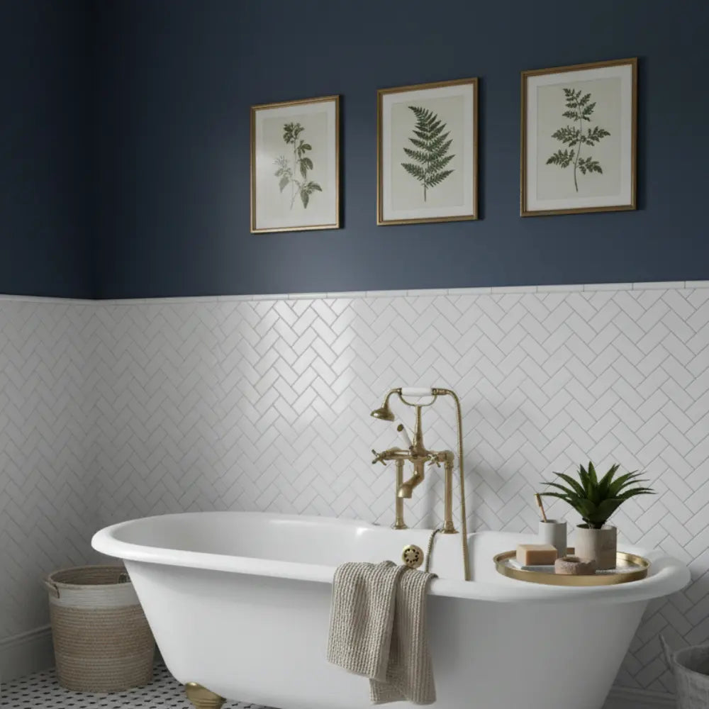 Bathroom with a freestanding bathtub, gold fixtures, and framed botanical prints on the wall.